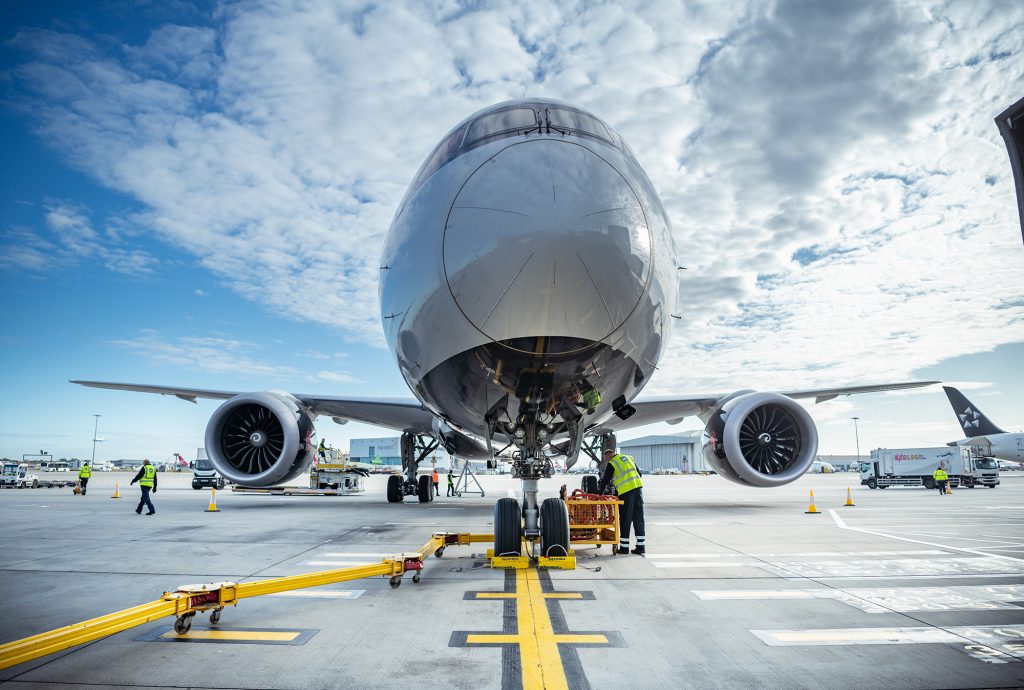 Ground handling team servicing an aircraft on the airport tarmac.