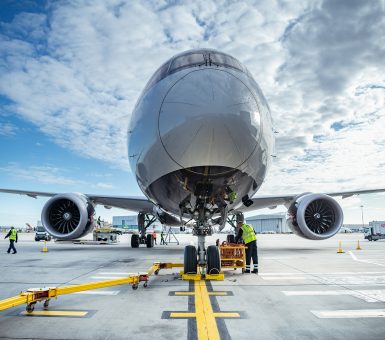 Ground handling team servicing an aircraft on the airport tarmac.
