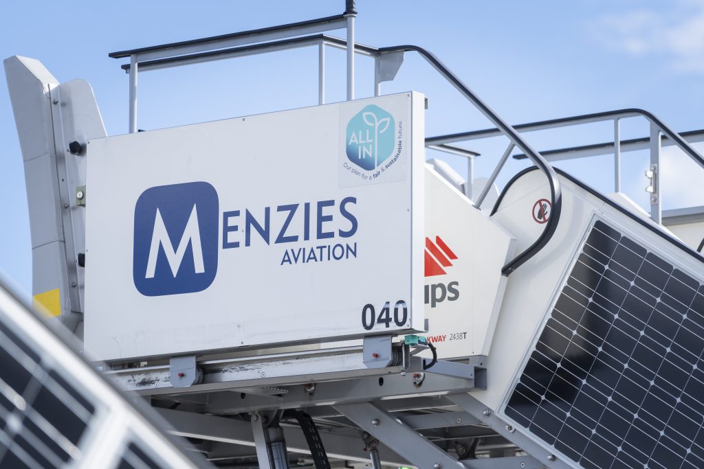 Menzies Aviation ground support equipment fitted with solar panels and sustainability branding.