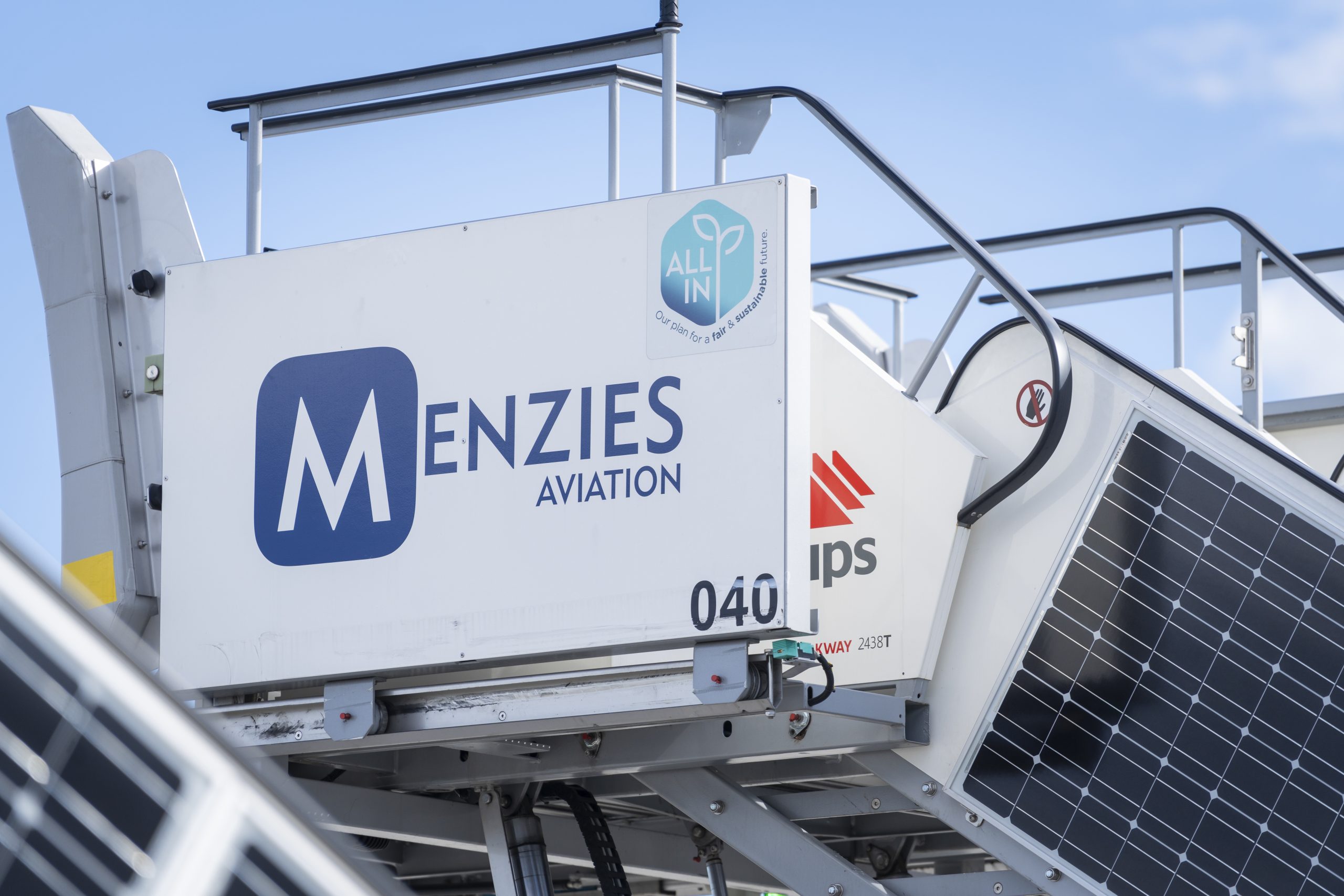 Menzies Aviation ground support equipment fitted with solar panels and sustainability branding.