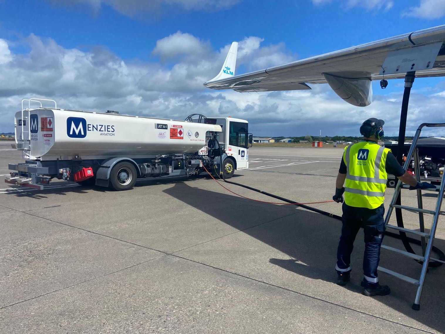 Menzies Aviation fuelling operator refuelling a KLM aircraft on the airport apron.