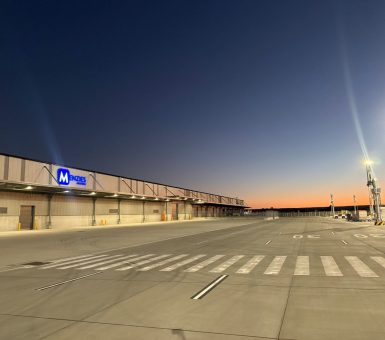 Menzies Aviation cargo facility at Western Sydney International Airport illuminated at dawn.