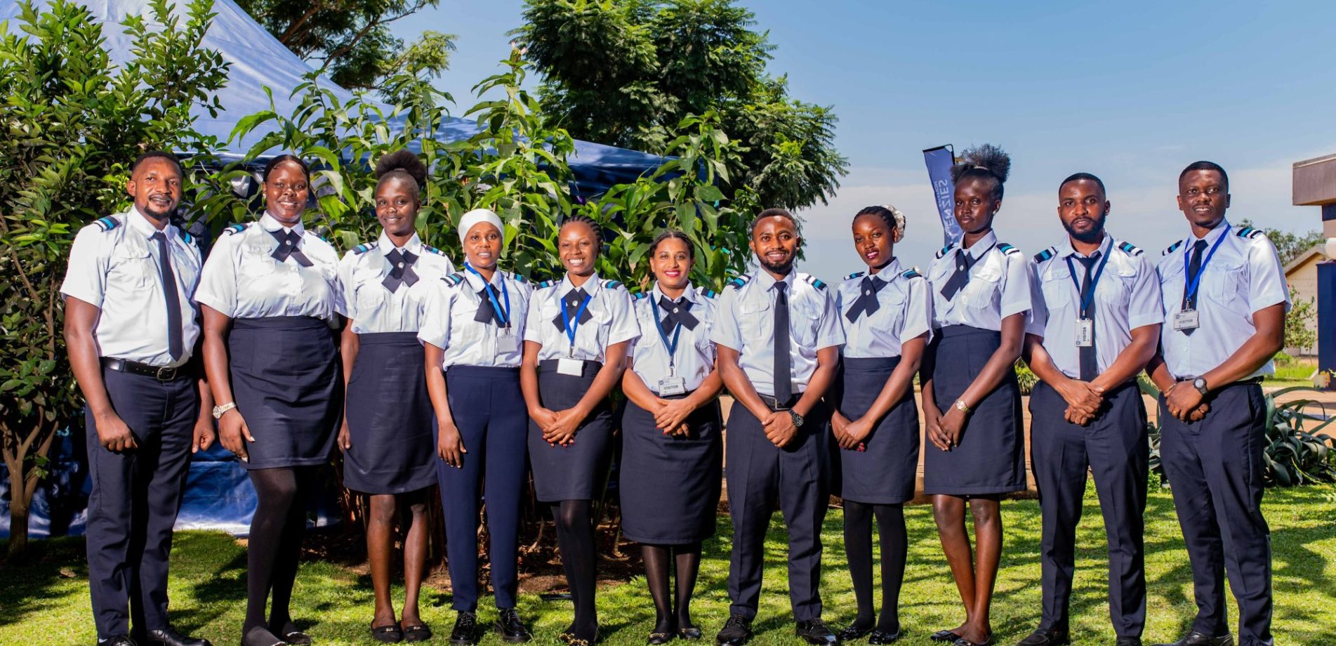 Group of aviation training school participants standing outdoors in uniform during a team photograph.