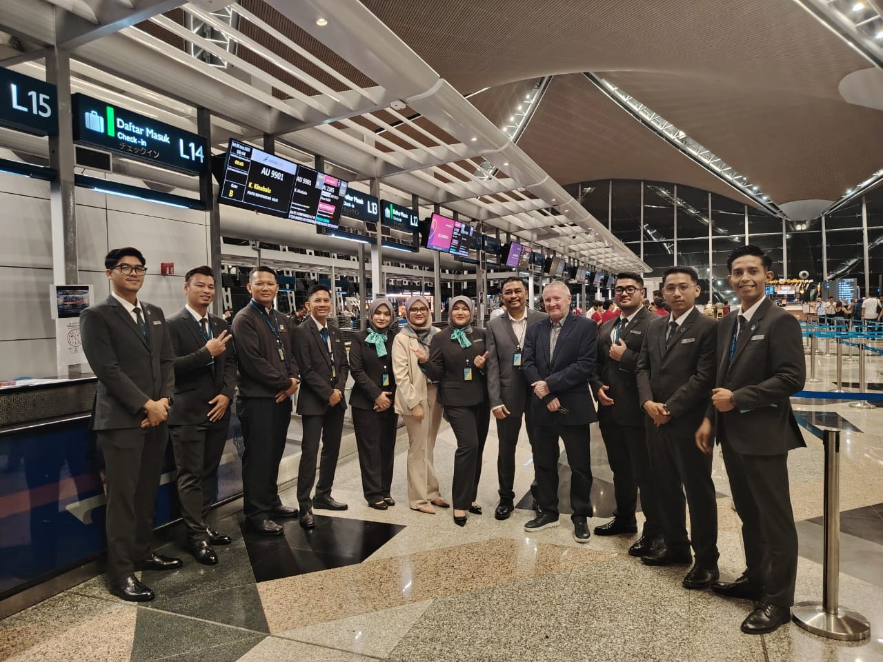 Menzies Aviation passenger services team gathered at check-in counters at Kuala Lumpur International Airport.